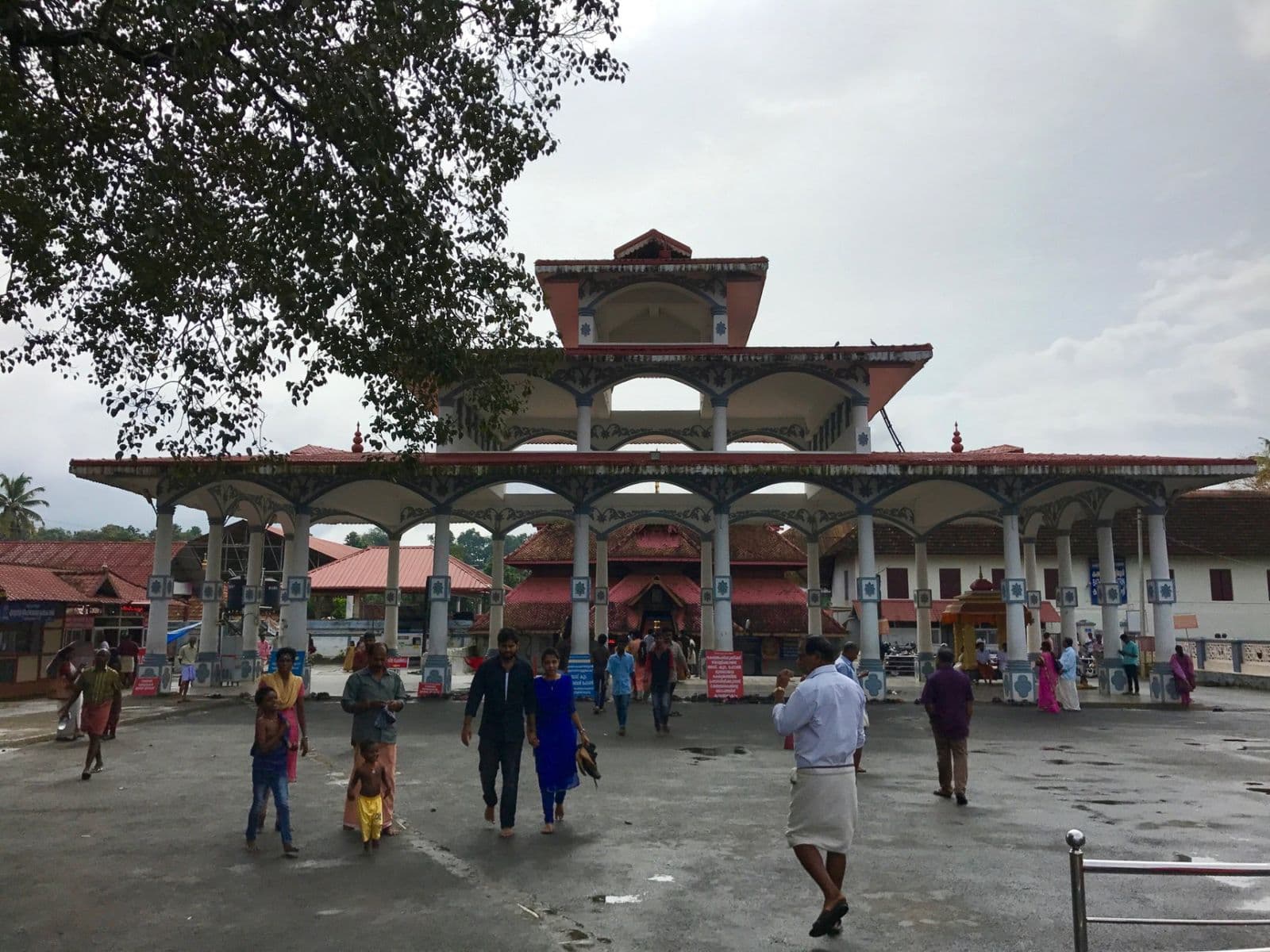 The ornate entrance pavilion of Ettumanoor Mahadeva Temple, with visitors in the courtyard