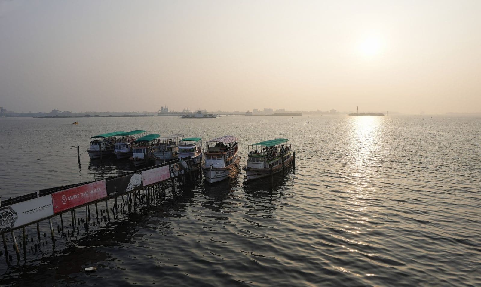 Tour boats moored at Marine Walk in Ernakulam as the sun sets over the harbour