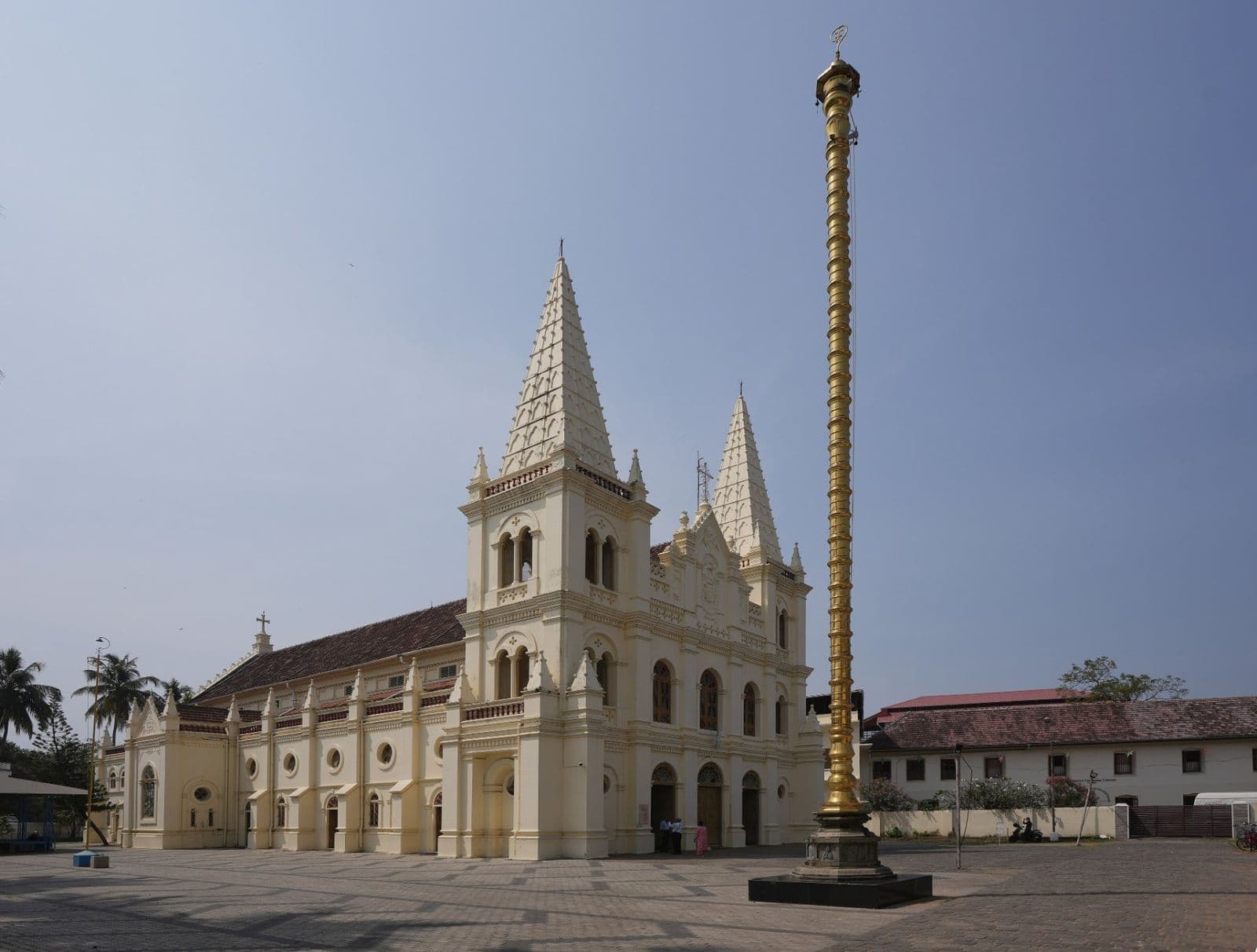 The white twin-spired facade of Santa Cruz Basilica beside a tall flagpole