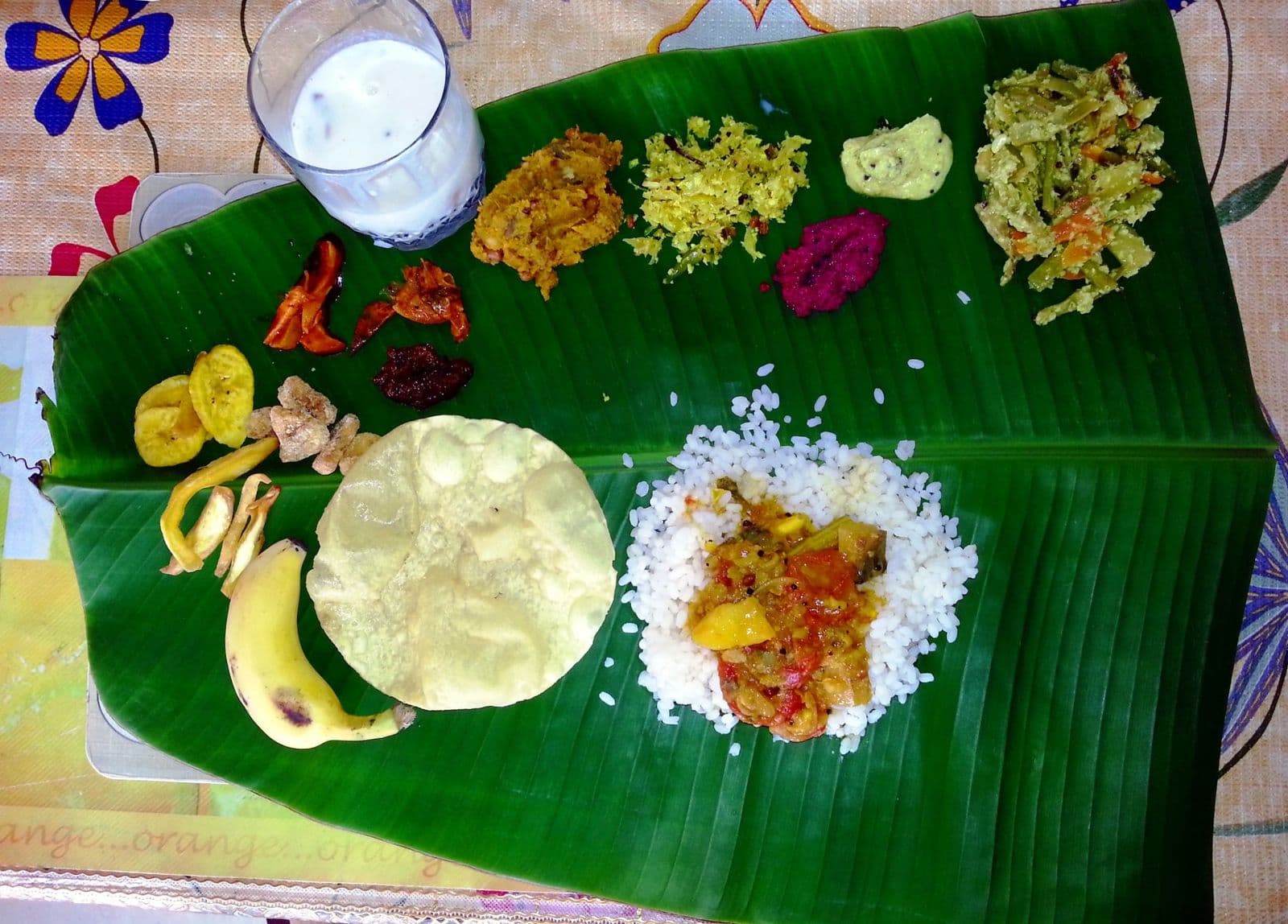 A Kerala sadya served on a banana leaf: rice, sambar, papadam, banana and a dozen side dishes